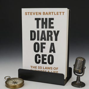 Peut inclure: Un livre intitul&eacute; "THE DIARY OF A CEO" de Steven Bartlett, pr&eacute;sent&eacute; dans un pr&eacute;sentoir noir. Un microphone vintage et une boussole sont &eacute;galement pr&eacute;sents. Le sous-titre du livre est "THE 33 LAWS OF BUSINESS & LIFE."