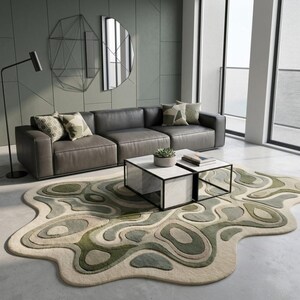 Może przedstawiać: Nowoczesny salon z szarą skórzaną sofą modułową, dwoma kwadratowymi stolikami kawowymi z marmurowymi blatami i czarnymi ramami oraz unikalnym dywanem o abstrakcyjnym, warstwowym wzorze w odcieniach zieleni i beżu. Dekoracyjne poduszki i lampa podłogowa dopełniają przestrzeń.