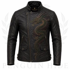 May include: A black leather jacket featuring an asymmetrical front zipper, a stand-up collar, and quilted shoulder panels. An intricate dragon embroidery in shades of green and gold adorns the chest. The label reads PENGUIN HIDE.