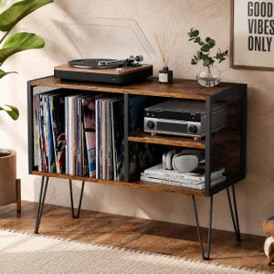 May include: A mid-century modern record player console with a turntable, stereo receiver, and vinyl records. The console is made of wood and black metal, with hairpin legs. A framed print reads "Good Vibes Only."