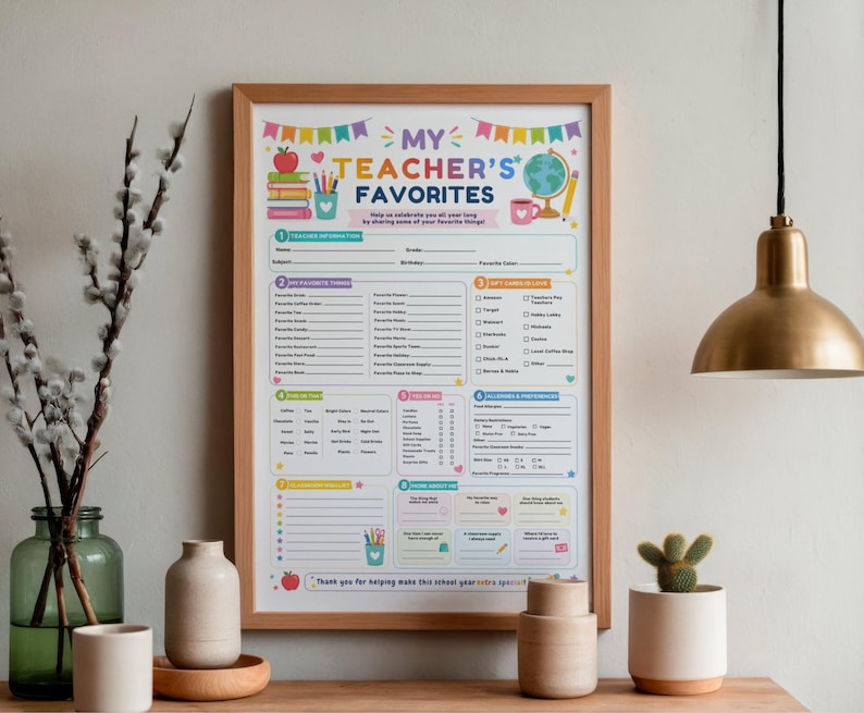 May include: A framed "My Teacher's Favorites" questionnaire poster with a light wood frame. The white paper features colorful graphics of books, a globe, and pencils, with sections for teacher information, gift card preferences, and personal interests.
