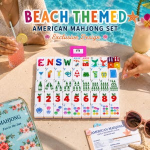 Op de afbeelding: Een American Mahjong-set met strandthema bestaande uit witte tegels met kleurrijke illustraties van drankjes, strandspullen en cijfers. De set bevat een roze rekje, een bloemrijke opberghoes en een naslaggids op een zanderige ondergrond.
