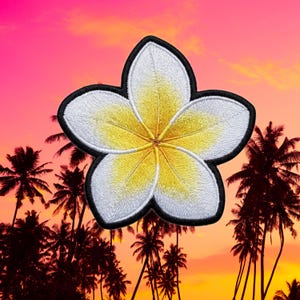 May include: Embroidered white and yellow plumeria flower patch with a black border. The tropical flower is set against a sunset backdrop with palm trees, evoking a sense of vacation and relaxation. Ideal for adding a touch of paradise to clothing or accessories.
