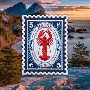 May include: A rectangular embroidered patch designed like a vintage postage stamp. It features a red lobster centered within an oval frame, surrounded by the text MAINE, POSTAGE, and U.S.A., with the number 5 and the cent symbol in the corners.