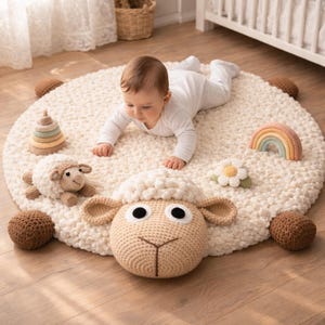 Könnte beinhalten: Ein cremefarbener, runder Babyspielteppich mit einem großen gehäkelten Schafkopf und mehreren gehäkelten Spielzeugen. Die Spielzeuge umfassen ein kleines Schaf, einen Regenbogen, eine Blume und ein Stapelspielzeug. Der Teppich hat eine strukturierte, weiche Oberfläche.