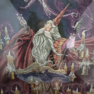 May include: A detailed tapestry depicting a wizard with a long white beard and a red hat, surrounded by candles and a starry background. The wizard is holding a staff and an open book. The artwork has a fantasy theme.