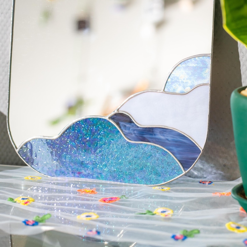 Stained glass cloud mirror detail with textured blue glass and soft light reflection