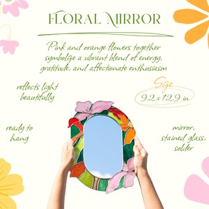 Stained glass floral mirror with pink and orange flowers held in hands outdoor