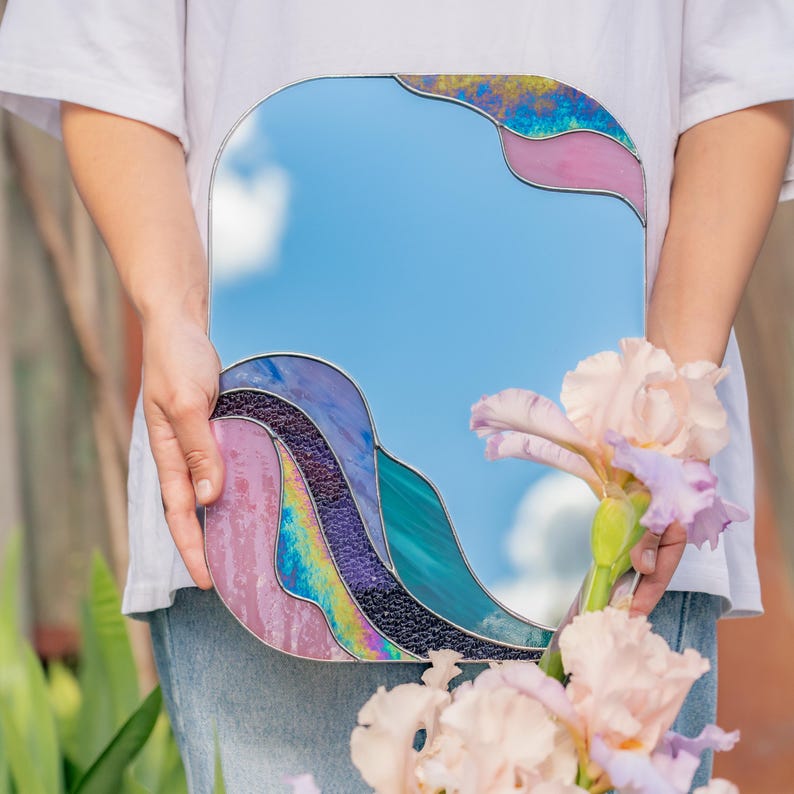 Stained glass colorful waves mirror held by person with flowers soft pastel glass handmade decor
