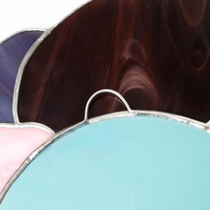 Close up stained glass pansy mirror with textured purple glass detail