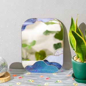 Stained glass cloud mirror reflecting greenery in bright sunlit interior