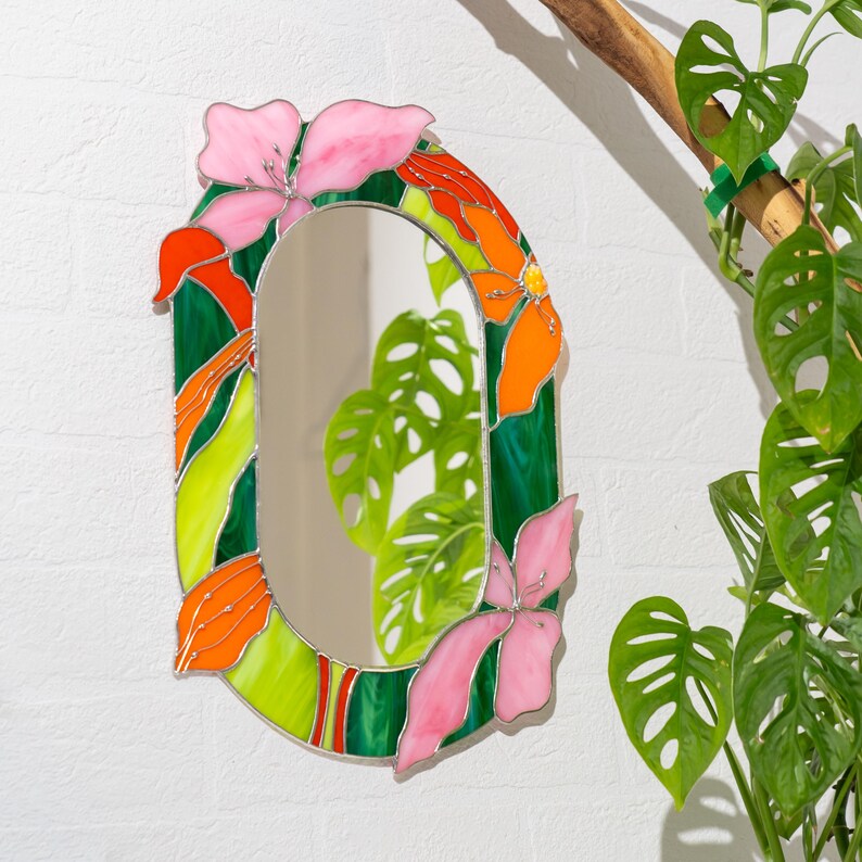 Stained glass floral mirror styled in interior with plants and natural light
