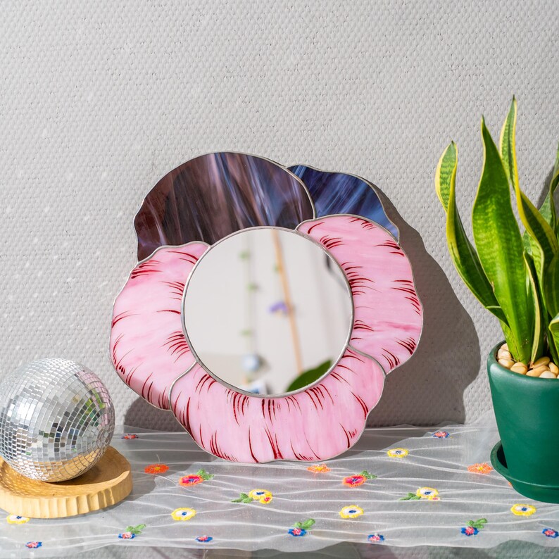 Stained glass pansy mirror on table with disco ball and plant decor