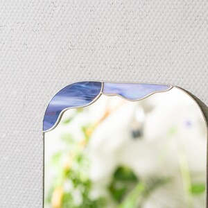 Close up of stained glass cloud mirror showing blue glass and smooth solder lines