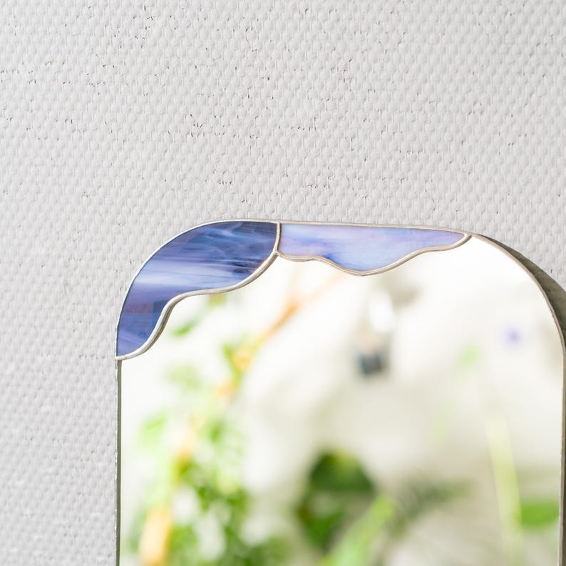 Close up of stained glass cloud mirror showing blue glass and smooth solder lines