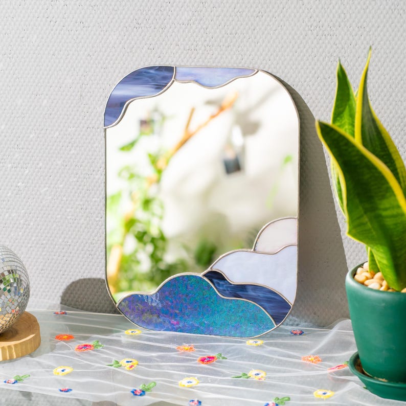Stained glass cloud mirror on table with plant decor and soft natural light