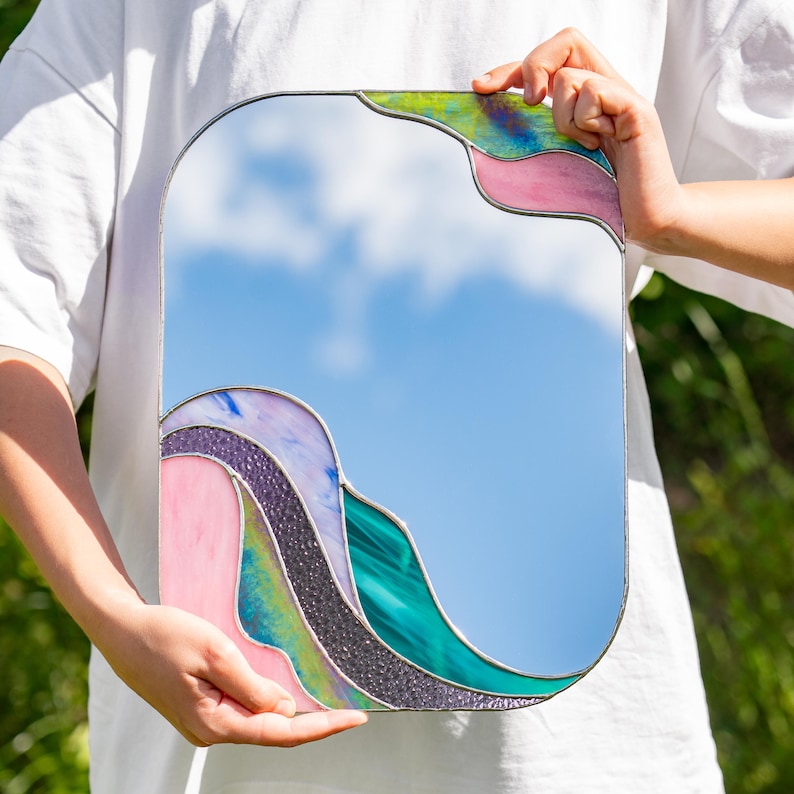 Stained glass colorful waves mirror held by person outdoor modern artistic glass home decor piece