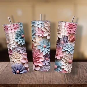 Puede incluir: Tres vasos de acero inoxidable con tem&aacute;tica floral y pajitas. Los vasos est&aacute;n decorados con flores 3D en colores pastel, incluyendo rosa, azul y crema. Los vasos son cil&iacute;ndricos y miden aproximadamente 20 cm de alto.