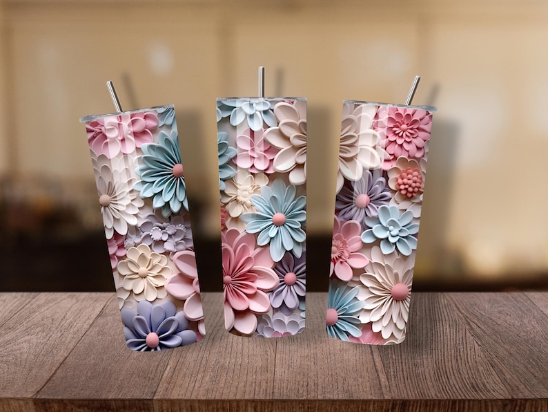 Puede incluir: Tres vasos de acero inoxidable con tem&aacute;tica floral y pajitas. Los vasos est&aacute;n decorados con flores 3D en colores pastel, incluyendo rosa, azul y crema. Los vasos son cil&iacute;ndricos y miden aproximadamente 20 cm de alto.