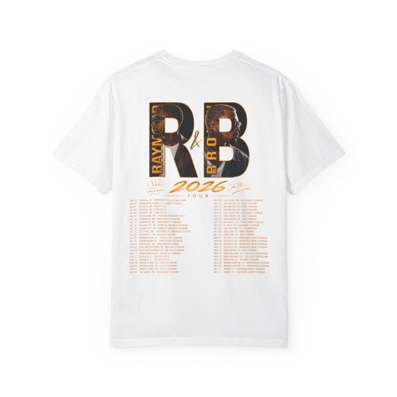 May include: A white short-sleeve t-shirt featuring a graphic on the back with the text RB, Raymond & Brown, and 2026 Tour. The design includes two portraits of men inside the letters R and B, along with a list of tour dates and stadium locations.
