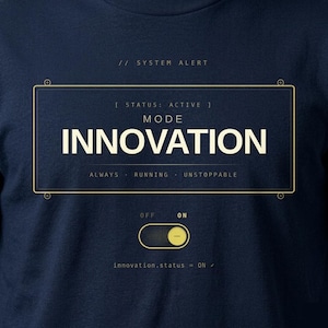 Pode incluir: Camiseta azul marinho com um design gráfico. O design apresenta a palavra "INNOVATION" em letras brancas grandes, com o texto "ALWAYS RUNNING UNSTOPPABLE" abaixo. A camiseta também inclui o texto "SYSTEM ALERT" e "innovation.status = ON".