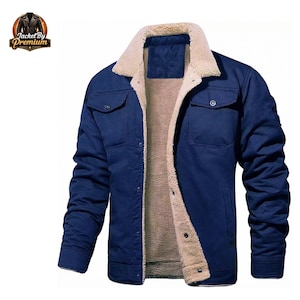 Puede incluir: Chaqueta azul marino con cuello y forro de piel sintética beige. La chaqueta tiene dos bolsillos en el pecho y cierres de botón. El logotipo "Jacket By Premium" está en la esquina superior izquierda.