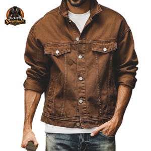 May include: A brown denim jacket with a button-up front, two chest pockets, and a classic collar. The jacket has a relaxed fit and is made of a sturdy material. The jacket is a medium brown colour.