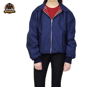 May include: A navy blue jacket with a red and black tartan lining, a silver zip, and two front pockets. The jacket features a collared neckline and ribbed cuffs. The logo "Jacket By Premium" is in the upper left corner.