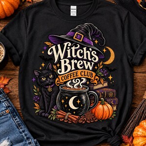 Puede incluir: Una camiseta negra con un estampado gráfico de un gato negro con collar morado y dije de pentagrama, un sombrero de bruja, una taza de café con una luna creciente, libros apilados, ramas de canela y una calabaza con el texto Witch's Brew.