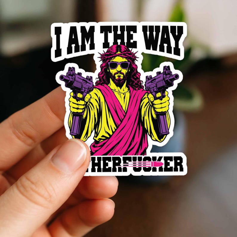 May include: A die-cut sticker featuring a graphic illustration of a bearded figure wearing a crown of thorns and sunglasses, holding two submachine guns. The text reads I AM THE WAY at the top and includes a partial word at the bottom with a bullet icon.