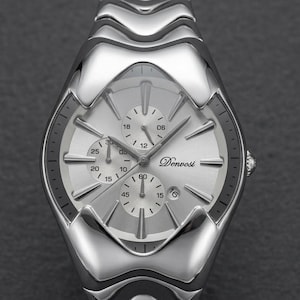 May include: A silver-toned wristwatch with a textured band and a light-colored face. The watch features multiple sub-dials and the brand name "Denvosi". The watch has a polished, reflective finish, and the band has a unique, wave-like design.