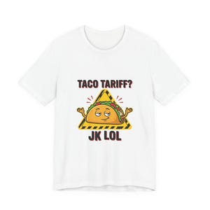 Könnte beinhalten: Weißes T-Shirt mit einem Cartoon-Taco-Design in einem gelben Gefahrenschild. Das Schild trägt die Aufschrift "TACO TARIFF?" über dem Taco und "JK LOL" darunter. Der Taco hat ein lächelndes Gesicht und ausgestreckte Arme.