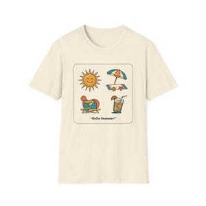 Könnte beinhalten: Cremefarbenes T-Shirt mit einem quadratischen Aufdruck mit Sommer-Symbolen. Das Design zeigt eine lächelnde Sonne, einen Sonnenschirm, einen Liegestuhl und einen Cocktail. Der Schriftzug "Hello Summer" ist darunter gedruckt.