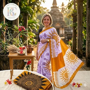 May include: A woman wearing a white, yellow, and purple batik sari with a sunburst design. The sari is draped over her shoulders. The image includes a folded batik textile with a circular pattern and the text "LADY & GENTS MODERN BATIK".