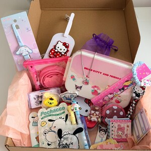 Peut inclure: Une boîte en carton remplie de divers articles sur le thème de Hello Kitty et Sanrio. Les articles comprennent une boîte à lunch rose, un collier, une règle, des stylos, un carnet, une étiquette à bagages et d'autres accessoires. La boîte est doublée de papier de soie rose.