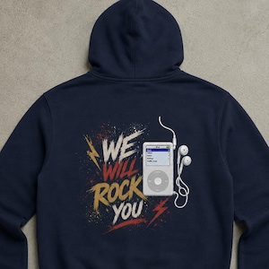 Pode incluir: Uma camisola com capuz azul-marinho com um gráfico nas costas. O design inclui o texto "WE WILL ROCK YOU" em branco e dourado, um leitor de música digital branco e auriculares com fio brancos, acentuados por raios vermelhos e amarelos.