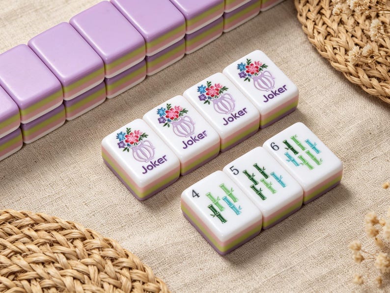 May include: A set of rectangular mahjong tiles with a layered design featuring a purple top, a light green middle, and a light purple base. Three tiles display a floral vase graphic with the text Joker, while three tiles show bamboo stalks.