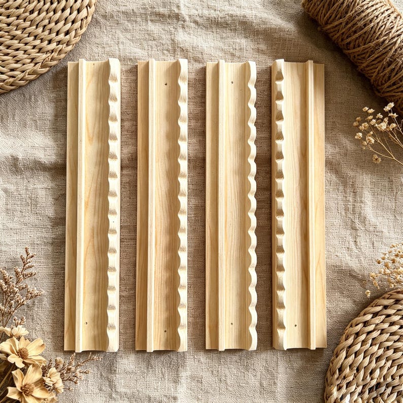 May include: Four rectangular light-colored wooden wall shelves arranged vertically. Each shelf features a smooth flat surface with a distinct scalloped or wavy edge detail along one side and a raised vertical ridge running down the center.