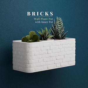 May include: White rectangular wall plant pot with a brick design, holding various succulents. The pot is mounted on a dark teal wall. Text on the image reads "BRICKS Wall Plant Pot with Inner Pot."