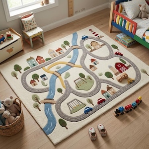 May include: A rectangular area rug featuring a cream-colored background with a colorful, tufted town map design. The rug displays winding gray roads, a blue river, green trees, various houses, a red barn, and small toy cars and swings.