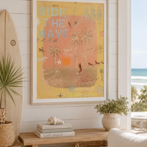 May include: A framed wall art print featuring a yellow background with the text RIDE THE WAVE in blue. The illustration includes palm trees, a sun, horses, and handwritten notes that read MAYBE THIS IS WHERE IT STARTS and BONFIRE CLEAN LINES OUTDOORS SHOWER SUNSETS.