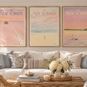 以下が含まれることがあります： The New Yorker誌の表紙を額装した3枚のウォールアートプリント。砂浜の車、砂の上で逆立ちをする人、浅瀬で犬と遊ぶ人など、パステルカラーで描かれた海岸の風景がそれぞれに表現されています。