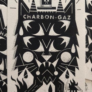 Peut inclure: Estampe en linogravure noir et blanc représentant un chat stylisé avec le texte "CHARBON-GAZ". L'œuvre comprend des formes géométriques, des flammes et une petite maison. L'estampe est numérotée 43/60.