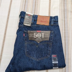 Può includere: Una tazza di ceramica bianca con manico nero e la scritta "But First, Coffee" in grassetto nero. La tazza è posta su uno sfondo sfocato, che suggerisce un'atmosfera accogliente.