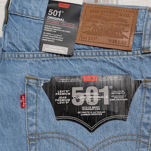 Könnte beinhalten: Handgefertigtes Holzschild mit dem Text "Welcome to our home" in handschriftlichem Stil. Das Schild ist weiß mit schwarzer Schrift bemalt und hat ein Used-Finish, ideal für die Inneneinrichtung.