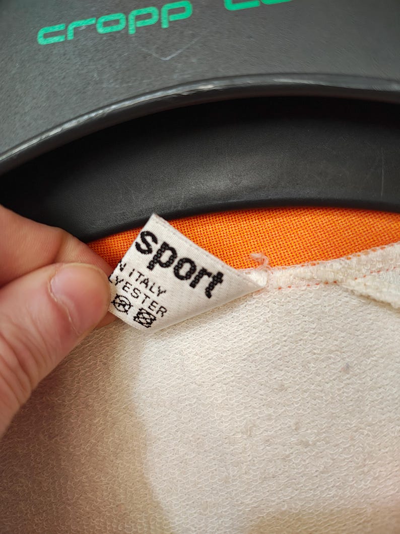 Puede incluir: Una taza de cer&aacute;mica blanca con un asa negra y el texto "But First, Coffee" en un estilo manuscrito. La taza est&aacute; sobre una superficie blanca. La taza mide aproximadamente 10 cm de alto.