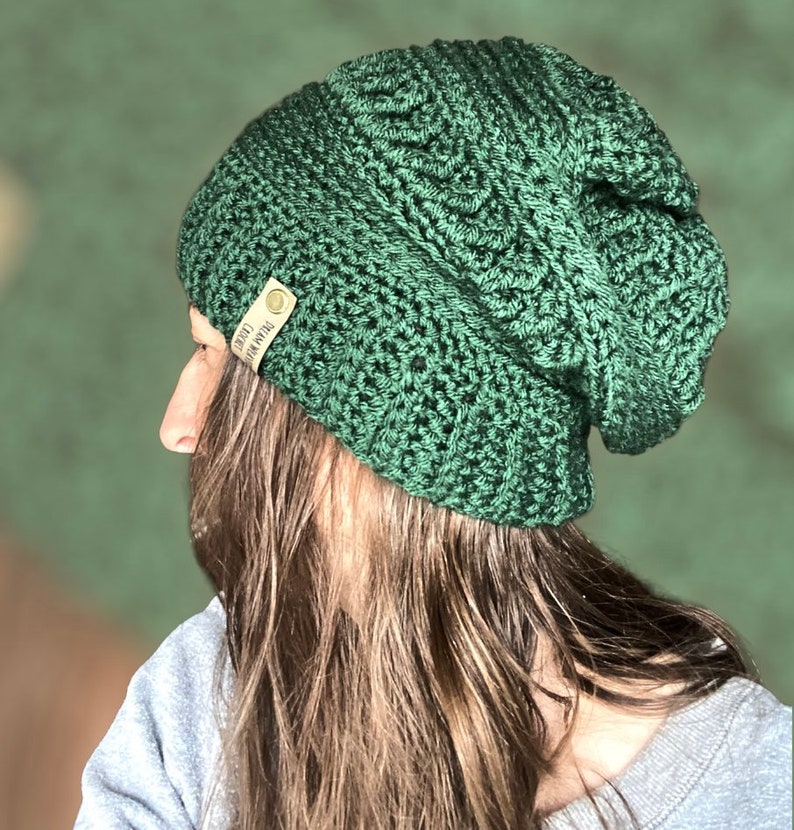 May include: A green crocheted beanie with a brown leather tag that says "Handmade with Love".