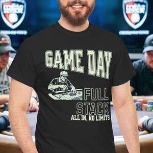 May include: A black t-shirt with the words "GAME DAY" in a bold, off-white font. Below the text is an illustration of a poker player and the words "FULL STACK ALL IN, NO LIMITS". The shirt is worn by a man.