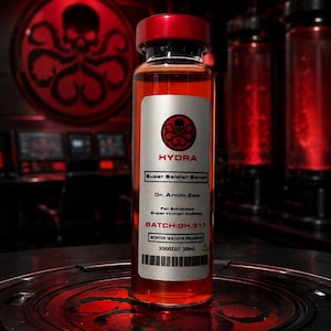 Könnte beinhalten: Eine durchsichtige Glasflasche gefüllt mit roter Flüssigkeit und einem roten Verschluss. Das Etikett trägt die Aufschrift HYDRA Super Soldier Serum, Dr. Arnim Zola, For Enhanced Super Human Abilities, BATCH:GH.317, WINTER SOLDIER PROGRAM, 3000IU/ 30ml. mit Strichcode.