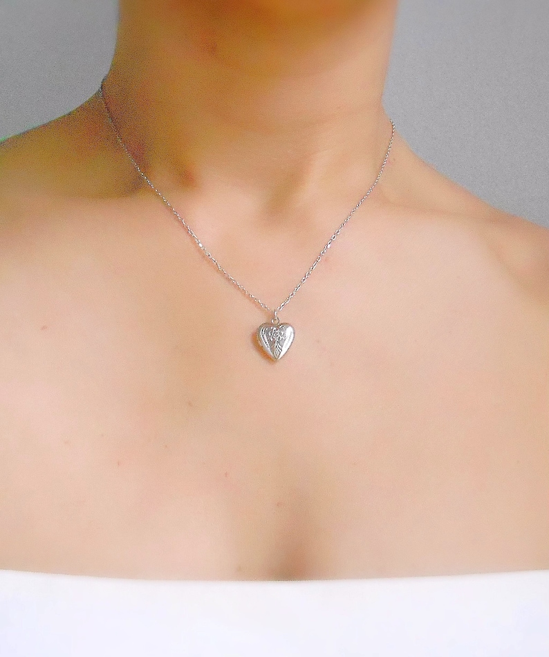 Pu&ograve; includere: Una collana d'argento con un ciondolo a forma di cuore.